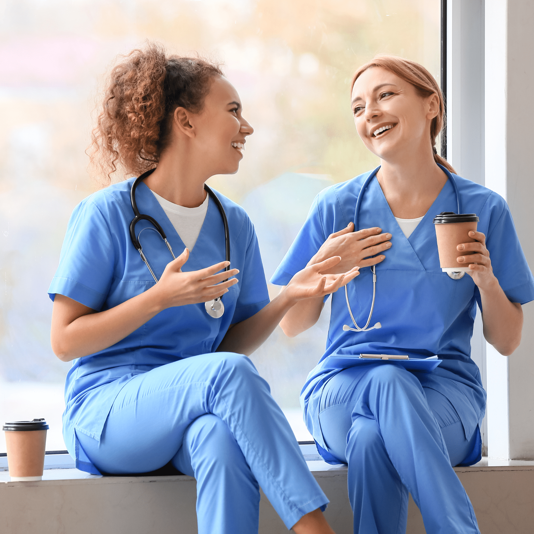 Two female nurses drinking coffee and talking