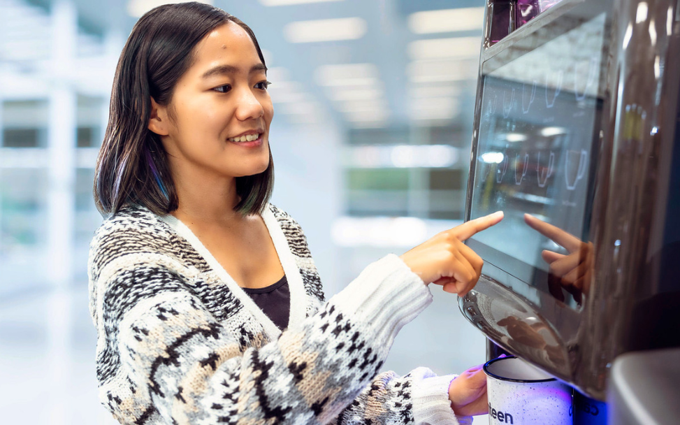 Woman using touchscreen coffee machine, ptwmt coffee services, single serve coffee, office coffee and tea
